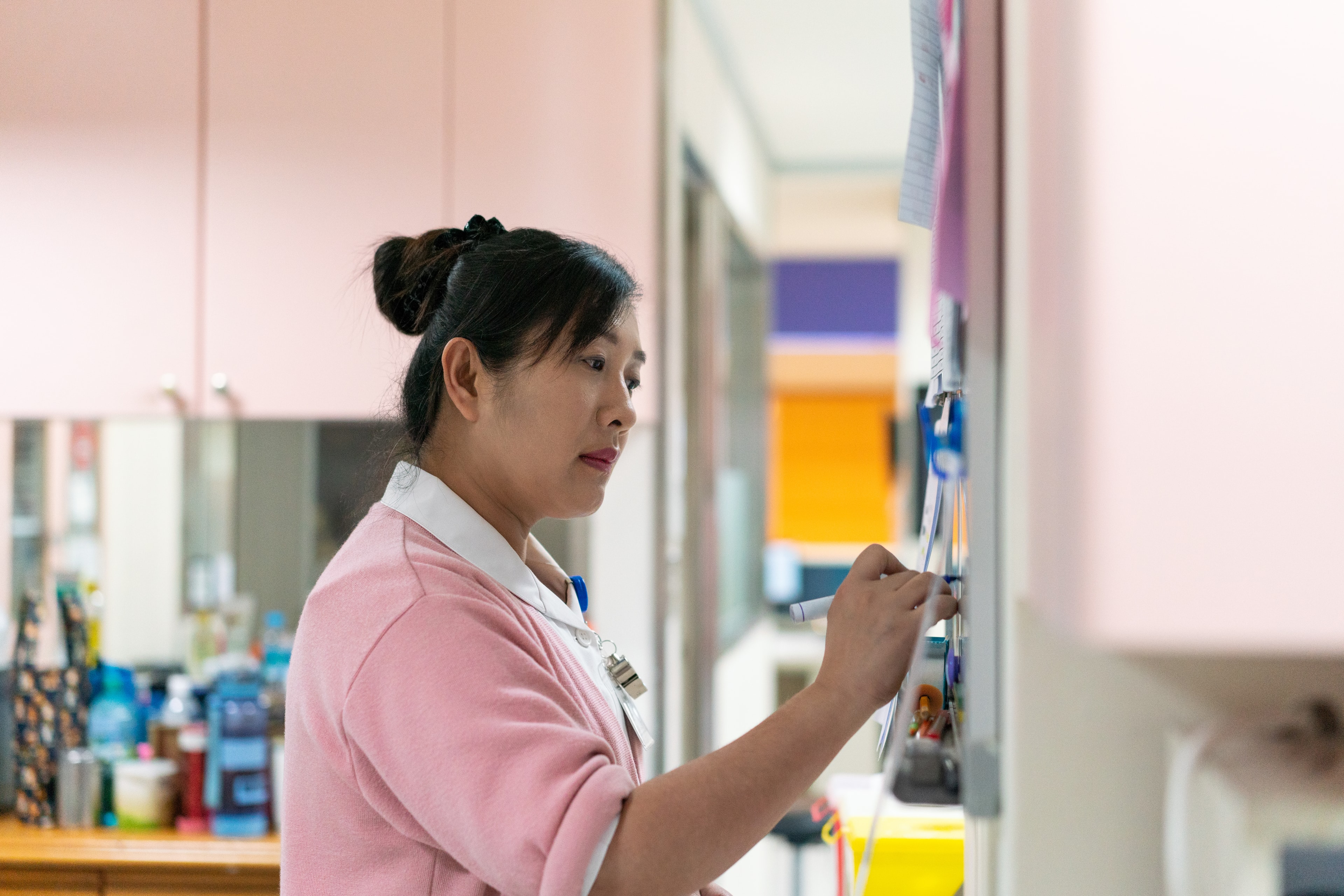 Nurse in hospital writing on chart